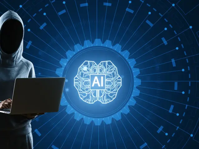 hooded-figure-using-laptop-with-ai-brain-graphic